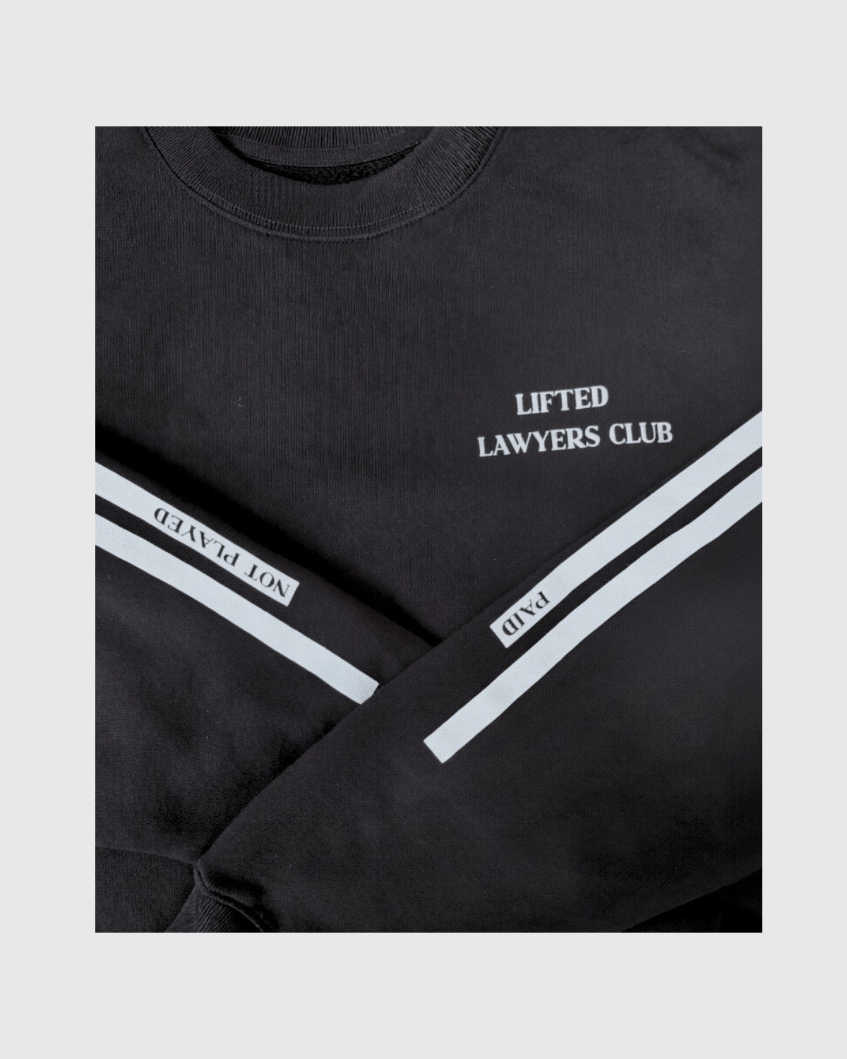 Black sweatshirt with 'Lifted Lawyers Club' text and white stripes on a light gray background