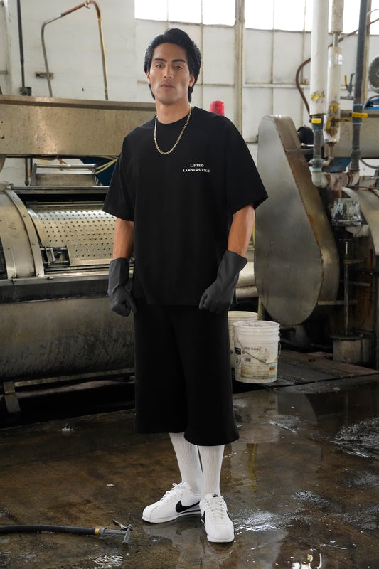 Model wearing the Heritage Logo black t-shirt and shorts in an industrial setting (Black)